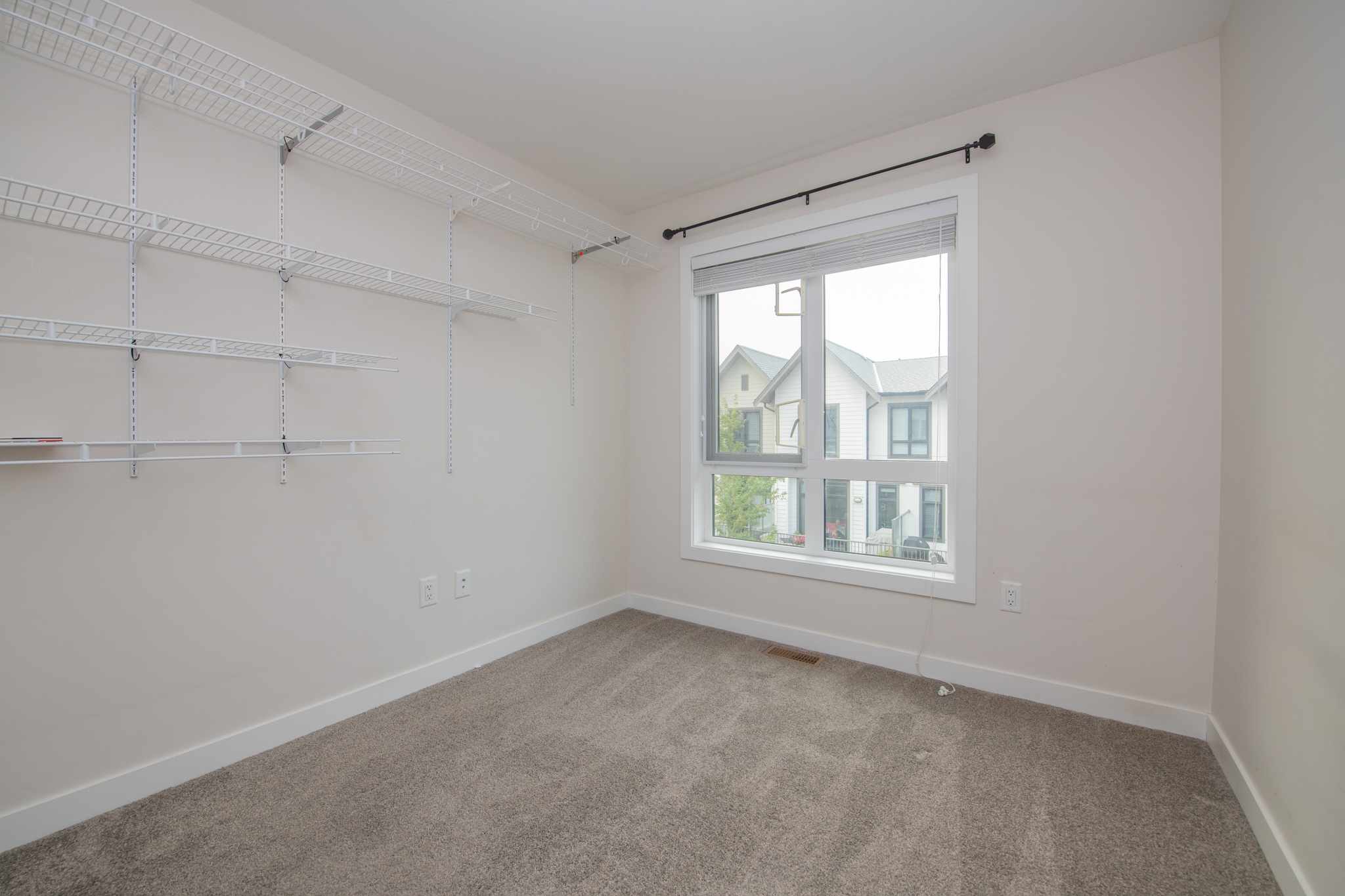 Bright secondary bedroom with built-in wall shelving